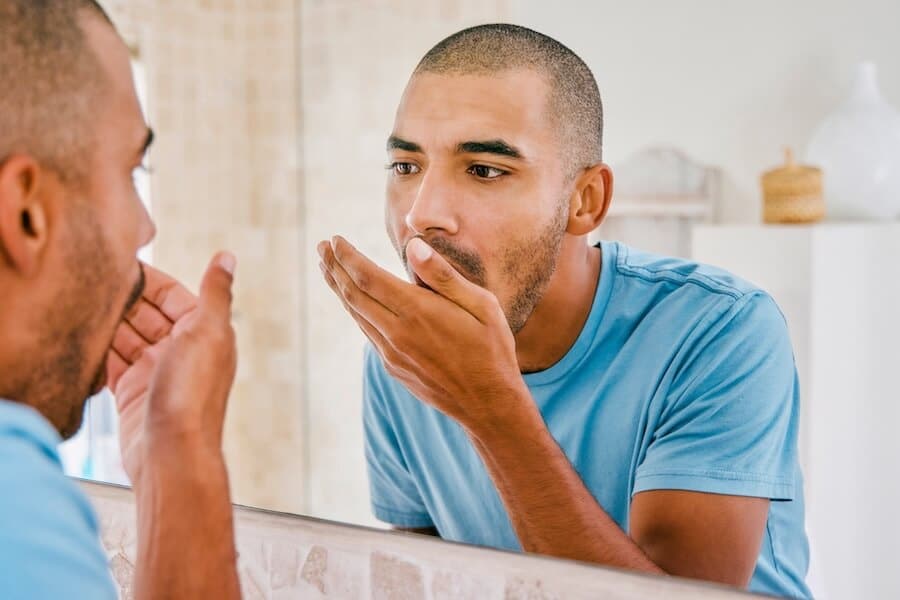 man checking if he has bad breath