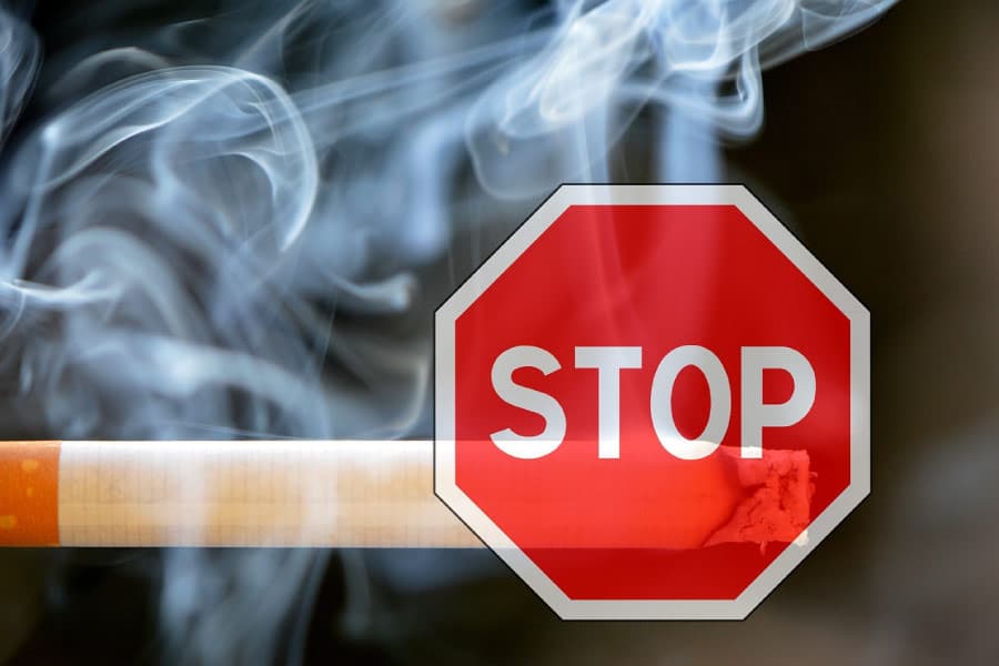 Stop sign superimposed over a smoking cigarette.